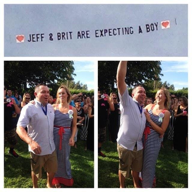 A couple standing in front of a sign that says " jeff & brit are expecting a boy ".