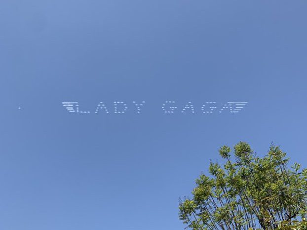 A lady gaga airplane flying in the sky.